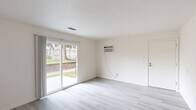 Located at 12433 Horizon Village Dr in Saint Louis, MO, this single-story, 2-bedroom, 1-bathroom home offers a straightforward and functional layout. The living room is a bright, open space featuring light gray luxury vinyl plank flooring, white walls, a textured ceiling, and a wall-mounted AC unit. A sliding glass door fills the room with natural light and provides direct access to an outdoor patio area with views of the surrounding greenery. An adjacent dining area connects seamlessly to the kitchen, which is equipped with gray cabinetry featuring decorative hardware, light stone-patterned countertops, and a stainless steel double-basin sink. Both bedrooms are carpeted with a multi-toned patchwork-style carpet and receive natural light through standard windows. The spacious primary bedroom includes closet access and ample room for furnishings. The full bathroom is clean and simply appointed, featuring a tub/shower combo with a white surround, chrome fixtures, and a wall mirror. Three closets throughout the home provide practical storage. A dedicated utility room, entrance, and hallway complete the interior. The home's single-level design and efficient use of space make it a practical and comfortable residence.