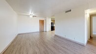 Located at 2215 Ambassador Rd NE in Albuquerque, NM, this single-floor, 2-bedroom, 2-bathroom unit offers a well-organized layout designed for comfortable living. The living room is a standout space, featuring durable wood-look flooring, a textured ceiling, a ceiling fan, and a charming white-painted brick fireplace flanked by a sliding glass door that opens to an outdoor area, allowing for natural light and ventilation. The kitchen is equipped with warm wood cabinetry, light countertops, and a full suite of black appliances including a gas range, dishwasher, and refrigerator, all set over easy-care hard surface flooring. Both bedrooms are carpeted and feature ceiling fans, providing a cozy atmosphere. The primary bedroom is generously sized and includes two closets for ample storage. The second bedroom also offers closet space and connects conveniently to the hallway. The two bathrooms are cleanly appointed, with one featuring a vanity with light countertops and wood-look flooring that continues into the hallway. Throughout the unit, a neutral color palette and consistent finishes create a cohesive and inviting atmosphere.