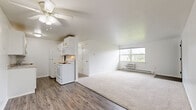 Located at 4719 Wilmington Pike in Kettering, Ohio, this 2-bedroom, 2-bathroom unit offers a practical and well-organized single-floor layout. The open-concept living room and kitchen area form the heart of the unit, with durable hardwood-style vinyl flooring in the kitchen transitioning to plush carpeting throughout the living and bedroom spaces. A ceiling fan overhead adds comfort to the living area, which benefits from a window offering views of the surrounding greenery.

The galley-style kitchen is efficiently arranged with white cabinetry, granite-look countertops, a stainless sink, and white appliances including a refrigerator, electric range, and built-in microwave. Ample upper and lower cabinet storage maximizes the compact space.

Both bedrooms are carpeted and naturally lit through windows, each equipped with a ceiling fan. The primary bedroom is generously sized and provides direct access to the hallway. A dedicated closet adds convenient storage.

The two bathrooms are finished with distinctive hexagonal tile flooring in a gray and white pattern, lending a classic yet stylish touch. Each bathroom includes a white vanity with mirror cabinet and clean white fixtures. One bathroom features a full tub/shower combination, while the other is appointed with a vanity and toilet.