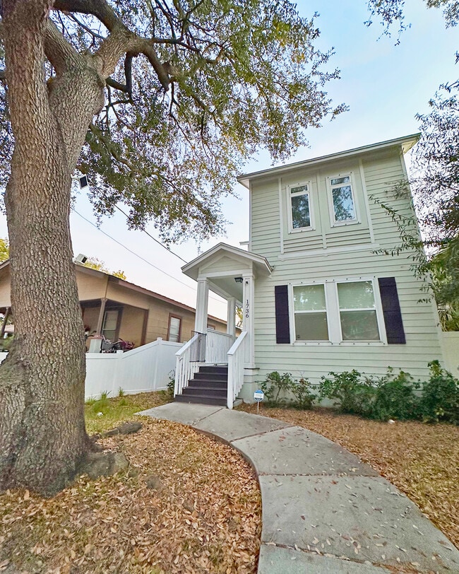 Charming front exterior with mature trees and welcoming porch. - 1736 W Walnut St House