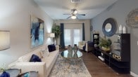 This thoughtfully designed 2-bedroom, 2-bathroom residence delivers a cohesive and modern living experience across a single floor. The open-concept kitchen is a standout feature, showcasing rich dark-espresso cabinetry, granite countertops, a tile backsplash, and a full suite of black appliances including a refrigerator, range, and built-in microwave. A peninsula with an integrated sink provides additional prep space and connects seamlessly to the dining and living areas. The living room is generously proportioned, featuring wood-style flooring, a ceiling fan, and access to natural light through French doors fitted with blinds. A dedicated dining area offers an intimate setting adjacent to the main living space. Both bedrooms are carpeted and well-sized, each equipped with ceiling fans and ample room for full bedroom furnishings. The primary bedroom features large windows that invite natural light, while both rooms offer a calm, restful ambiance. The two full bathrooms mirror each other in finish quality, each featuring granite-topped dark vanities, large mirrors, wood-style flooring, and a tub-shower combination. The consistent use of neutral tones, granite surfaces, and dark cabinetry throughout creates a unified and polished aesthetic.