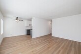 Located at 425 E Bradley Ave in El Cajon, California, this single-floor, 2-bedroom, 1-bathroom unit offers a clean and efficiently designed layout. Light wood flooring runs consistently throughout, lending warmth and continuity to the space. The living room is bright and open, featuring dual windows with blinds that allow ample natural light, a ceiling fan, a wall-mounted HVAC unit, and a textured ceiling — creating a comfortable and airy atmosphere. An adjacent dining area connects seamlessly to the galley-style kitchen, which is well-appointed with two-tone cabinetry — white uppers and gray lowers — granite countertops, a subway tile backsplash, stainless steel appliances including a refrigerator, electric range, and built-in microwave, plus a stainless undermount sink. The spacious primary bedroom offers generous room to furnish comfortably and includes a large window with outdoor views of surrounding greenery. The second bedroom is equally well-lit and includes a sliding closet. Three closets in total provide practical storage throughout the unit. The bathroom features a full tub/shower combination with classic white subway tile surround and brushed nickel fixtures. The overall aesthetic is clean, bright, and move-in ready.