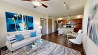 This thoughtfully designed 2-bedroom, 2-bathroom residence offers a comfortable and functional single-floor layout. The open-concept living and dining area is bright and welcoming, featuring rich hardwood-style flooring, large windows with blinds that invite abundant natural light, and a ceiling fan overhead. The kitchen is a standout feature, showcasing warm cherry wood cabinetry, granite countertops, a large center island with a double sink and bar seating, pendant lighting, stainless steel appliances, and track lighting — all flowing seamlessly into the main living area. Both bedrooms are carpeted and generously sized, with the spacious primary bedroom offering ceiling fan, ample natural light, and dedicated closet space. The second bedroom is equally comfortable, featuring similar finishes and ceiling fan. Each bathroom is well-appointed with wood-toned vanities, white countertops, and a tub-shower combo. A dedicated in-unit laundry room includes a full-size washer and dryer. The entrance and hallway provide practical transitions between rooms, complemented by two closets for storage. A private balcony extends the living space outdoors, overlooking well-maintained landscaping and greenery.