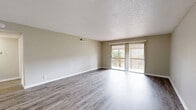 Located at 3400 Townsend Blvd in Jacksonville, Florida, this 2-bedroom, 2-bathroom residence offers a well-organized single-floor layout designed for comfortable everyday living. The two living areas provide flexible spaces for relaxation or entertaining, with one featuring durable wood-style flooring and a sliding glass door that opens to a private balcony with outdoor views, while vertical blinds offer adjustable light control. A second living area also includes a sliding glass door, bringing in natural light and continuing the connection to the outdoors. The kitchen is a functional highlight, outfitted with grey shaker-style cabinetry, a white subway tile backsplash, light countertops, a double basin sink, and black appliances including a refrigerator and dishwasher, all set on wood-style flooring. The spacious primary bedroom features plush carpet flooring, a large window for natural light, and ample closet storage with bifold doors. The second bedroom is similarly carpeted and well-proportioned. Both bathrooms are finished with wood-style flooring, full tub-shower combinations with tiled surrounds, and white vanities. A connecting hallway ties the layout together, and neutral warm-toned walls throughout create a clean, cohesive aesthetic.