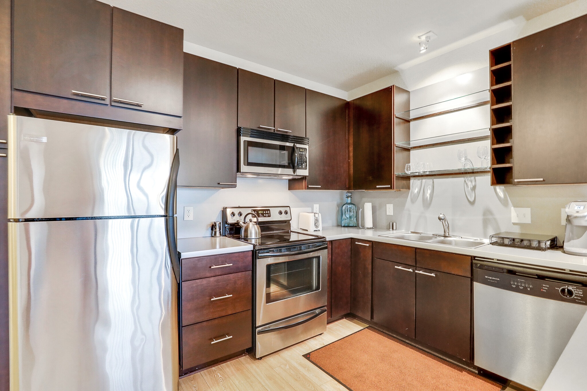 Modern kitchen with stainless steel appliances and dark wood cabinets.