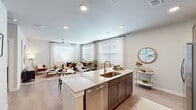 Located at 22103 Gosling Road in Spring, TX, this single-story residence offers a thoughtfully designed 2-bedroom, 2-bathroom floor plan that maximizes comfort and functionality. The open-concept kitchen, dining, and living area serves as the heart of the home, anchored by a large center island with granite countertops, a stainless steel undermount sink, and bar seating. Dark espresso cabinetry contrasts beautifully with the light countertops, while stainless steel appliances — including a refrigerator, range, and built-in microwave — complete the modern kitchen. Light wood-style flooring flows throughout the main living areas, enhancing the bright, airy atmosphere created by multiple large windows dressed in white blinds and sheer curtains. Ceiling fans are featured in both the living room and bedrooms. The spacious primary bedroom offers generous natural light and is complemented by a walk-in closet with wire shelving systems. The second bedroom is equally well-lit and comfortable. Both bathrooms are finished with granite-topped vanities, dark cabinetry, and tiled tub-shower combinations. Each bedroom is served by its own dedicated walk-in closet, providing ample storage throughout this clean, contemporary home.