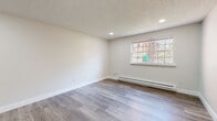 Located at 90 Lawton St in Springfield, Massachusetts, this single-floor unit has been thoughtfully updated with contemporary finishes throughout. The flooring is a standout feature, with light gray luxury vinyl plank running consistently across the living areas and bedrooms, offering both durability and a clean, modern aesthetic.

The spacious living and bedroom areas share a cohesive design language: neutral white walls, crisp white baseboards, recessed lighting, and textured ceilings. Each room benefits from natural light provided by multi-pane windows, and baseboard heating units line the walls, ensuring year-round comfort.

The kitchen is a clear highlight of the unit, featuring white shaker-style cabinetry, a mosaic tile backsplash, recessed and pendant lighting, and stainless steel appliances including a range and refrigerator. A sink is positioned beneath a window, allowing natural light into the space, while the open layout connects seamlessly to the adjacent living area.

The bathroom is neatly finished with wood-look ceramic tile flooring, a tub and shower combination enclosed by a sliding glass door, and clean white fixtures. A panel-style door with brushed nickel hardware adds a polished touch to the entry.

Overall, the unit presents a clean, move-in ready interior with consistent modern updates and a practical, well-organized layout.