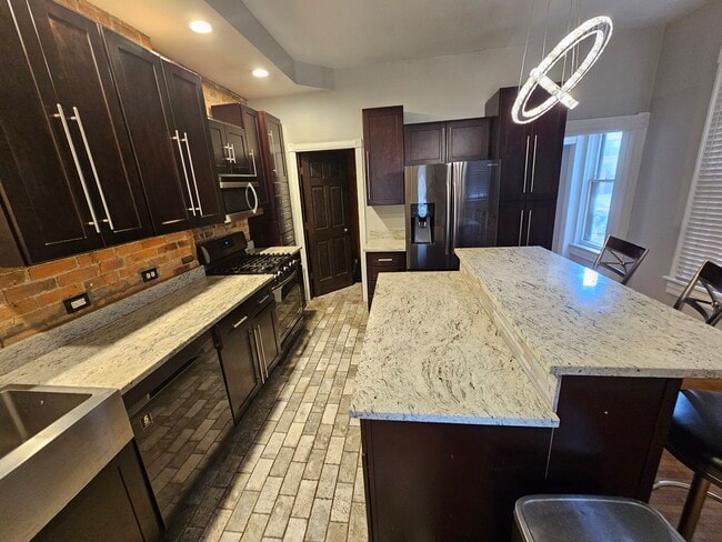 Some exposed brick/modern stainless steel appliances and New York Brick tile. - 943 Highland St