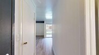 Located at 120 S Kingston Dr in Bloomington, Indiana, this single-floor unit offers a practical and well-organized layout across a compact footprint. The main living area is bright and open, featuring light wood-look flooring that runs throughout the space, crisp white walls, and a distinctive dark exposed beam accent that adds a subtle architectural detail to the ceiling. Natural light enters through a window and a sliding glass door that opens onto an outdoor patio area, enhancing the sense of openness. A built-in sliding-door closet provides generous storage within the living space.

The kitchen is efficiently designed with dark cabinetry contrasted against white appliances, including a range and sink, with ample counter space for meal preparation. It is positioned in a corner layout that maximizes functionality within the available space.

The bathroom is clean and straightforward, finished in white with wood-look flooring that matches the rest of the unit. It includes a full tub-shower combination, a toilet, and a wall-mounted sink, all neatly arranged for practical daily use.

Overall, the unit presents a clean, move-in-ready aesthetic with consistent finishes throughout, offering a comfortable and functional living environment in Bloomington, IN.