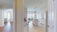 Located at 150 Du Rhu Dr in Mobile, Alabama, this two-story home offers a well-designed layout with a blend of functional and classic architectural details throughout. The kitchen is a standout feature, equipped with white cabinetry, granite countertops, a center island with pendant lighting, a gas range, and a bay window area that fills the space with natural light. Tile flooring runs through the kitchen, while rich hardwood floors extend through the dining and living areas. Elegant arched doorways connect the main living spaces, adding a refined architectural touch. The dining area is highlighted by a chandelier and a large window, creating a bright and inviting atmosphere. The primary bedroom suite includes plush carpeting, a walk-in closet with built-in shelving, and a private en-suite bathroom featuring both a soaking tub with jets and a separate glass-enclosed shower. An additional bathroom offers a white vanity with ample cabinet storage and tile flooring. Throughout the home, neutral tones and white trim create a clean, cohesive aesthetic. The attached two-car garage includes a built-in wooden storage shelf along the wall and an automatic door opener, providing convenient and practical additional space.