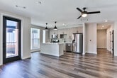 Located in Atlanta's vibrant 30312 zip code, this single-floor residence delivers a thoughtfully designed open-concept layout with contemporary finishes throughout. Rich, dark hardwood-style flooring flows through the main living areas, complemented by neutral walls and generous windows that invite abundant natural light. The expansive living area features a ceiling fan and direct access to a private balcony, offering views of the surrounding community. The kitchen is a standout, equipped with light wood cabinetry, a soft gray subway tile backsplash, quartz countertops, stainless steel appliances, a central island with pendant lighting, and a deep undermount sink. The primary bathroom is elegantly appointed with a wide dual-sink vanity, wood-toned cabinetry, matte black fixtures, a large framed mirror, and a glass-enclosed tiled shower with built-in shelving. A second full bathroom mirrors the same modern aesthetic. The bedroom features plush carpeting, a ceiling fan, and tall windows with outdoor views. Additional highlights include a spacious walk-in closet with wire shelving and a dedicated laundry room with a full-size front-loading Whirlpool washer and dryer. This residence combines practical functionality with refined, modern design.