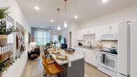This single-story, 2-bedroom, 2-bathroom residence in Slidell, Louisiana, offers a thoughtfully designed open-concept layout that maximizes functionality and flow. Light wood-style flooring runs throughout the main living areas, complementing the bright white walls and recessed lighting that give the space an airy, modern feel.

The living area features large windows and a glass door that flood the room with natural light, while decorative barn-style wall mirrors and a ceiling fan add character. This space flows seamlessly into the dining area and kitchen, creating an ideal open floor plan.

The kitchen is well-equipped with white shaker-style cabinetry, granite-look countertops, white appliances including an electric range, microwave, and refrigerator, and a central island with pendant lighting and bar seating — ideal for casual dining or meal prep.

Both bedrooms are carpeted and receive natural light through blinded windows. Ceiling fans are present in each room, and both feature access to their respective bathrooms. The bathrooms include granite-topped vanities, white cabinetry, and tub-shower combinations with clean, neutral finishes throughout.