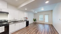 Located at 2700 N Hayden Pkwy in Roseville, CA, this 2-bedroom, 1-bathroom unit offers a clean, modern design across a well-utilized single floor. The open-concept living and kitchen area is anchored by rich wood-look flooring and crisp white walls, creating a bright and welcoming atmosphere. Recessed lighting and a flush ceiling fixture illuminate the space, while a front-facing door with an adjacent window allows natural light to fill the living area.

The kitchen is thoughtfully appointed with white shaker-style cabinetry, dark countertops, and black appliances including a refrigerator, gas range with overhead ventilation, and dishwasher. A stainless steel sink with a modern faucet completes the functional workspace.

Both bedrooms continue the wood-look flooring and neutral palette, with windows fitted with blinds that provide natural light and privacy. The spacious primary bedroom includes direct access to a dedicated walk-in closet outfitted with full-length shelving and hanging rods. The bathroom features accessibility-focused design with grab bars near the toilet and vanity, dark countertops, and a large mirror. A dedicated laundry area rounds out the practical layout of this well-designed Roseville residence.