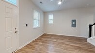 Located at 2909 Shoals Point Way in Leland, NC, this two-story home offers 3 bedrooms and 3 bathrooms thoughtfully distributed across two well-proportioned floors. The main level features a bright, open-concept layout combining the living room, dining area, and kitchen into one cohesive space. The kitchen is a standout, boasting crisp white shaker cabinets, speckled granite countertops, a central island with pendant lighting, and a full suite of stainless steel appliances including a refrigerator, range, microwave, and dishwasher. Natural light pours in through multiple windows fitted with blinds throughout the home. Warm hardwood-style flooring runs consistently across both floors, lending a clean and unified aesthetic. A dedicated laundry area and staircase connect the two levels. The upper floor houses the bedrooms, including a spacious primary bedroom with a walk-in closet featuring wire shelving. The primary bathroom is well-appointed with a dual-sink vanity topped in granite, white cabinetry, and a glass-enclosed walk-in shower. Secondary bathrooms mirror the same refined finishes. Each bedroom is light-filled with multiple windows and ceiling fans. Three closets provide ample storage throughout the home.