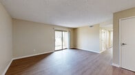 Located at 8100 Perry St in Overland Park, Kansas, this single-floor, two-bedroom, one-bathroom residence offers a practical and comfortable layout with modern finishes throughout. Wood-look laminate flooring flows seamlessly across the main living areas, lending a cohesive and clean aesthetic. The open combined living and dining area is bright and welcoming, featuring a sliding glass door that connects the space to an outdoor patio and fills the room with natural light. Textured ceilings are present throughout the home. The kitchen stands out with crisp white shaker cabinetry, a subway tile backsplash, light-toned countertops with a peninsula sink, stainless steel appliances, and a skylight that adds additional natural illumination. The spacious primary bedroom includes a ceiling fan, a sliding closet, and its own sliding glass door to the patio. The second bedroom also features a ceiling fan, a window with natural light, and hardwood-style flooring. Both rooms are served by four closets distributed throughout the unit. The full bathroom is outfitted with a tub-shower combination. A dedicated laundry area and utility room provide added convenience, completing this well-appointed Overland Park residence.