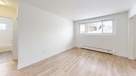 Located at 325 Home St in Stratford, Ontario, this one-bedroom, one-bathroom unit offers a clean, modern aesthetic throughout its efficiently designed single-floor layout. Light-toned hardwood flooring runs seamlessly across the living spaces, creating a bright and cohesive feel from room to room.

The kitchen is well-appointed with crisp white shaker-style cabinetry, dark countertops, and a classic white subway tile backsplash. Stainless steel appliances — including a range, over-the-range microwave, and dishwasher — provide a functional and stylish cooking environment. A double undermount sink adds practicality, and the galley-style layout makes efficient use of the available space.

The living room is a clean, open area with neutral white walls and large windows that allow natural light to fill the room, offering views of the surrounding neighbourhood. Baseboard heating is present throughout, ensuring year-round comfort.

The bedroom is a comfortable, well-proportioned room featuring the same light hardwood flooring and a large window that brings in additional natural light and neighbourhood views.

The bathroom is tastefully finished with full white subway tile surrounding the soaker tub and shower, complemented by a white vanity with a stone-look countertop and tile flooring. A small window adds ventilation and light. A hallway provides a functional entry point that connects all rooms in this thoughtfully laid-out home.