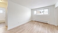 Located at 325 Home St in Stratford, Ontario, this one-bedroom, one-bathroom unit offers a clean, modern aesthetic throughout its efficiently designed single-floor layout. Light-toned hardwood flooring runs seamlessly across the living spaces, creating a bright and cohesive feel from room to room.

The kitchen is well-appointed with crisp white shaker-style cabinetry, dark countertops, and a classic white subway tile backsplash. Stainless steel appliances — including a range, over-the-range microwave, and dishwasher — provide a functional and stylish cooking environment. A double undermount sink adds practicality, and the galley-style layout makes efficient use of the available space.

The living room is a clean, open area with neutral white walls and large windows that allow natural light to fill the room, offering views of the surrounding neighbourhood. Baseboard heating is present throughout, ensuring year-round comfort.

The bedroom is a comfortable, well-proportioned room featuring the same light hardwood flooring and a large window that brings in additional natural light and neighbourhood views.

The bathroom is tastefully finished with full white subway tile surrounding the soaker tub and shower, complemented by a white vanity with a stone-look countertop and tile flooring. A small window adds ventilation and light. A hallway provides a functional entry point that connects all rooms in this thoughtfully laid-out home.