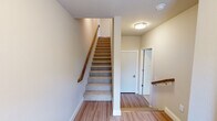 Located on Western Rd in Cedarburg, WI, this well-appointed three-story home offers five bedrooms and three bathrooms across a thoughtfully designed layout. The entry level provides a welcoming foyer with light wood-style flooring and carpeted staircases with warm wood handrails connecting all three floors.

The main living level features an open-plan kitchen and living room bathed in natural light. The kitchen is equipped with stainless steel appliances, warm wood cabinetry, granite countertops, a large center island with a double sink, pendant lighting, and a wine refrigerator. The adjoining living area showcases a sleek modern fireplace, recessed lighting, and sliding glass doors opening to a private balcony with outdoor views.

The upper floors house the five bedrooms, including a spacious primary suite, all finished with plush carpeting, ceiling fans, and generous windows that bring in ample natural light. The three bathrooms are finished with tile flooring and granite vanities; the full bathrooms feature tub-shower combinations with large-format tile surrounds and sliding glass enclosures.

Throughout, the home maintains a clean, neutral palette with crisp white trim, shaker-style interior doors, and consistent light wood flooring in common areas, creating a cohesive and modern aesthetic suitable for comfortable everyday living.