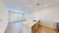 Located at 2966 Linden St in Bethlehem, PA, this well-appointed single-floor residence offers a thoughtfully designed layout with modern finishes throughout. The open-concept kitchen serves as the heart of the home, featuring sleek gray shaker cabinetry, striking marble-look quartz countertops, a peninsula island with a stainless steel sink, and stainless steel appliances including a dishwasher and range. Light wood-tone flooring runs throughout the main living areas, enhancing the bright, airy atmosphere created by recessed lighting and natural light from large windows. The den provides a flexible secondary space, while the balcony offers an outdoor retreat with views of the surrounding neighborhood. The primary bedroom is a comfortable retreat with plush carpeting, a ceiling fan, and its own closet access. Two additional closets throughout the unit provide generous storage. The full bathroom is finished with a white vanity, wood-look flooring, and a tub-shower combination enclosed by sliding glass doors. A dedicated laundry area adds everyday convenience. The hallway features clean white panel doors with brushed nickel hardware, tying together the home's cohesive, contemporary aesthetic.