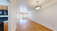 Located at 518 Fabra St in charming Boerne, Texas, this two-bedroom, one-bathroom single-story home offers a well-designed layout with comfortable living spaces throughout. The open living area greets you with warm wood-look flooring, vaulted ceilings, and a ceiling fan with a pendant light fixture, creating a bright and airy atmosphere. Natural light pours in through large windows, with views of surrounding greenery visible from the front entry. The galley-style kitchen features warm wood cabinetry lining both walls, light countertops, a stainless sink, and black appliances, including a full-size refrigerator. An adjacent laundry area adds everyday convenience. Both bedrooms are carpeted and equipped with ceiling fans, offering a cozy and quiet retreat. The spacious primary bedroom includes a window with outdoor views and direct access to the bathroom, which features a wood-vanity and a soaking tub. A dedicated walk-in closet with wire shelving provides ample storage. The home also includes a covered concrete patio accessible through a door off the living area, offering a relaxing outdoor space surrounded by mature trees — a fitting complement to this well-appointed Boerne residence.