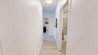 Located at 409 E Hills Blvd SE in Calgary, Alberta, this 2-bedroom, 2-bathroom unit offers a thoughtfully designed single-level layout that maximizes every square foot. The entrance leads into a bright, clean hallway finished with light wood-look flooring and crisp white walls, setting a modern and welcoming tone throughout.

The open-concept kitchen and dining area serve as the heart of the home. The kitchen features medium-toned wood cabinetry, light stone countertops, a white subway tile backsplash, and full black appliance suite including a refrigerator, electric range, and over-range microwave. A peninsula counter provides additional prep space and casual seating. The adjoining dining area is framed by a large window that brings in natural light, creating an airy atmosphere ideal for everyday meals.

The living room is comfortably sized with a large window overlooking the street, light flooring, and a neutral palette that suits a range of décor styles. Both bedrooms are well-proportioned, with the primary bedroom offering a comfortable retreat. The second bedroom also features a bright window and light carpet. Each of the two bathrooms is finished in clean white tile; one includes a glass-enclosed walk-in shower. Throughout the unit, the consistent use of light tones and modern finishes creates a cohesive, contemporary living environment.