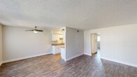 This 2-bedroom, 2-bathroom unit in Mesa, Arizona, offers a practical and well-organized single-story layout. Wood-style plank flooring runs throughout the main living areas and bedrooms, providing a cohesive and easy-to-maintain finish. The living room is an open, airy space anchored by a ceiling fan and a large window that welcomes natural light and views of the surrounding landscaping. A front entry door with an adjacent vertical-blind window adds additional brightness to the space.

The galley-style kitchen is efficiently designed with white shaker cabinetry lining both walls, laminate countertops, a single-basin sink, and black appliances including an electric range and dishwasher. A flush-mount ceiling light illuminates the space effectively.

The primary bedroom offers a comfortable footprint with a reach-in closet featuring a built-in shelf. Neutral wall tones and the consistent wood-style flooring carry through both bedrooms. The two bathrooms each feature white vanity cabinetry, laminate countertops, and wood-style tile flooring. One bathroom includes a walk-in shower, while the second offers a full shower-tub combination. A textured ceiling is present throughout the unit, complementing the clean, neutral interior palette.