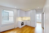 Located at 3495 Avenue Van Horne in the Côte-des-Neiges neighbourhood of Montréal, this well-designed one-bedroom, one-bathroom unit makes efficient use of its intimate footprint. The open layout connects the kitchen and living areas seamlessly, anchored by warm honey-toned hardwood flooring that runs throughout the main living spaces and bedroom.

The modern kitchen features clean-lined, floor-to-ceiling white cabinetry that maximizes storage, a sleek white countertop, an induction cooktop, a built-in Bosch oven, and a window that draws in natural light. The bright, white walls and recessed lighting keep the space feeling open and airy.

The bedroom offers a comfortable retreat with a large window overlooking neighbouring brick architecture, a radiator heating unit, and recessed lighting. Sliding closet doors provide practical storage within the room.

A dedicated in-unit laundry closet houses a stacked washer and dryer, adding significant everyday convenience rarely found in similarly sized units.

The bathroom is finished with neutral large-format tiles and features a glass-enclosed walk-in shower, a wall-mounted sink with modern cabinetry, a toilet, and an overhead rain-style shower fixture — delivering a clean, contemporary aesthetic. This unit is an ideal option for those seeking a functional, modern living space in Montréal.