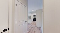 Located at 27S Main St in Attleboro, MA, this thoughtfully designed one-bedroom, one-bathroom unit offers a clean, contemporary aesthetic across a single floor. Light hardwood flooring flows seamlessly throughout every room, creating a cohesive and airy feel. The open-concept living area integrates the kitchen, dining, and living spaces into one functional zone. The kitchen is a standout feature, equipped with white shaker cabinetry extending to the ceiling, a white subway tile backsplash, gleaming quartz countertops, a central island with additional prep space, and a full suite of stainless steel appliances including a refrigerator, gas range, microwave, and dishwasher. The living and dining area benefits from a sliding glass door that opens to a balcony with views of the surrounding Attleboro streetscape, filling the space with natural light. The bedroom is a well-proportioned retreat with two windows offering additional outdoor views and a dedicated closet for storage. The bathroom features a full tub-shower combo, white vanity cabinetry, and matching hardwood-style flooring. A utility room rounds out the layout, adding practical storage and functionality. The unit's neutral palette of warm whites and soft greiges contributes to a bright, modern ambiance throughout.