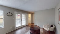 Located at 5639 Old Chapel Hill Rd in Chapel Hill, NC, this single-floor residence offers a well-designed layout that balances comfort and functionality. The living area features durable wood-style flooring, neutral gray walls, and a textured ceiling. A set of French doors with plantation shutters floods the space with natural light and provides direct outdoor access, creating an open, airy feel.

The galley-style kitchen is thoughtfully appointed with white upper cabinetry, gray lower cabinets, marble-style countertops, and black appliances, including a range and refrigerator. Light wood-style flooring ties the space together and enhances its clean, contemporary aesthetic.

The bedrooms are carpeted for added comfort and each features a ceiling fan with integrated lighting and a window with blinds. The layout, as seen in the dollhouse view, connects the bedrooms conveniently to the rest of the unit.

The bathroom is finished with a marble-style countertop, white cabinetry, a large mirror, and wood-style flooring. The tub-shower combination is lined with classic white tile and fitted with brushed nickel grab bars for added safety and accessibility.

A dedicated in-unit laundry closet houses a full-size GE washer and dryer, adding everyday convenience to this practical and well-maintained Chapel Hill residence.