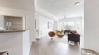 This thoughtfully designed single-floor residence offers a seamless blend of comfort and modern style across its well-proportioned layout. The open-concept living, dining, and kitchen area serves as the heart of the home, featuring light hardwood-style flooring, crown molding, and a textured ceiling with a ceiling fan. Large windows along the dining area flood the space with natural light and frame lush outdoor greenery, creating a bright and airy atmosphere throughout.

The kitchen is equipped with stainless steel appliances, including a range and over-the-range microwave, complemented by granite countertops, a tile backsplash, and gray cabinetry. A pass-through breakfast bar with seating connects the kitchen to the main living area, enhancing the open feel. A set of double doors off the kitchen provides additional storage.

The bedroom is a calm, carpeted retreat with a tray ceiling, a large window with outdoor views, and access to a walk-in closet. The bathroom continues the clean aesthetic with tile flooring, granite-topped vanity cabinetry, and direct access to the walk-in closet. Every room reflects a cohesive, neutral palette that maximizes the sense of space and light throughout the residence.