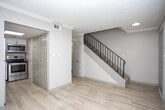Located at 806 Viking Dr in Smyrna, GA, this two-story home offers a well-organized layout distributed across two distinct levels. The entry level features light wood-style flooring that flows through the main living areas, complemented by neutral wall tones and textured ceilings throughout. A staircase with black metal railings connects the floors, and a window near the entry allows natural light into the space.

The kitchen is a functional highlight, equipped with white shaker-style cabinetry, light quartz-style countertops, stainless steel appliances including a range, microwave, and dishwasher, and a decorative mosaic tile backsplash in warm earth tones. A double-basin stainless steel sink anchors the workspace. One room on the main level features light wood-style flooring and crown molding details.

Upper-level rooms are carpeted and feature ceiling fans with pull-chain lighting. The primary bedroom includes dual reach-in closets with built-in shelving, offering ample storage. Additional carpeted bedrooms feature natural light from windows with blinds. The bathroom includes a vanity with light countertops, wood-style flooring, and a separate water closet, providing a clean and functional layout throughout.