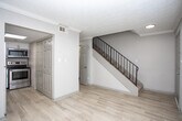 Located at 806 Viking Dr in Smyrna, GA, this two-story home offers a well-organized layout distributed across two distinct levels. The entry level features light wood-style flooring that flows through the main living areas, complemented by neutral wall tones and textured ceilings throughout. A staircase with black metal railings connects the floors, and a window near the entry allows natural light into the space.

The kitchen is a functional highlight, equipped with white shaker-style cabinetry, light quartz-style countertops, stainless steel appliances including a range, microwave, and dishwasher, and a decorative mosaic tile backsplash in warm earth tones. A double-basin stainless steel sink anchors the workspace. One room on the main level features light wood-style flooring and crown molding details.

Upper-level rooms are carpeted and feature ceiling fans with pull-chain lighting. The primary bedroom includes dual reach-in closets with built-in shelving, offering ample storage. Additional carpeted bedrooms feature natural light from windows with blinds. The bathroom includes a vanity with light countertops, wood-style flooring, and a separate water closet, providing a clean and functional layout throughout.