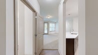 Located at 100 Spade Leaf Blvd in Hendersonville, Tennessee, this one-bedroom, one-bathroom residence offers a well-designed, single-floor layout that makes efficient use of its space. The open-concept living and kitchen area serves as the heart of the home, featuring rich dark espresso cabinetry, light quartz countertops, a breakfast bar peninsula with pendant lighting, and a full suite of stainless steel appliances including a refrigerator, electric range, microwave, and dishwasher. Light wood-style flooring runs throughout the kitchen, adding a clean, modern touch. The living area is generously proportioned, with plush carpeting, multiple large windows dressed with blinds, and a sliding glass door that opens to a private balcony, flooding the space with natural light and outdoor views of surrounding greenery. The bedroom is a comfortable retreat, also carpeted, with its own windows and a ceiling fan for year-round comfort. The bathroom offers dark cabinetry with ample drawer storage, light countertops, a large mirror, and a soaking tub with tile surround and light wood-style flooring. A dedicated laundry area and in-unit water heater provide added convenience. Overall, this residence presents a clean, contemporary aesthetic throughout.
