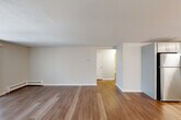 Located at 20 Bailey Ct in Canton, MA, this two-bedroom, one-bathroom single-floor residence offers a well-organized and functional layout. Throughout the home, light-toned hardwood-style flooring creates a clean, cohesive look that ties each room together seamlessly.

The open-concept living and kitchen area forms the heart of the home. The living room is bright and airy, featuring a sliding glass door that invites natural light and provides a view of the surrounding greenery. The kitchen is thoughtfully designed with gray shaker-style cabinetry, white countertops, and a full suite of stainless steel appliances including a refrigerator, range, microwave, and dishwasher — offering both style and practicality.

The spacious primary bedroom features darker hardwood-style flooring, a window with natural light, and generous closet space with double bi-fold doors. The second bedroom is equally well-appointed with its own closet and window. Four closets throughout the home provide abundant storage options.

The full bathroom is neatly finished with a white vanity, tiled tub-shower combination, and hardwood-style flooring. Baseboard heating is present throughout the home, ensuring year-round comfort. A hallway connects the living areas to the bedrooms and bathroom, completing this practical and move-in-ready residence.
