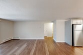 Located at 20 Bailey Ct in Canton, MA, this two-bedroom, one-bathroom single-floor residence offers a well-organized and functional layout. Throughout the home, light-toned hardwood-style flooring creates a clean, cohesive look that ties each room together seamlessly.

The open-concept living and kitchen area forms the heart of the home. The living room is bright and airy, featuring a sliding glass door that invites natural light and provides a view of the surrounding greenery. The kitchen is thoughtfully designed with gray shaker-style cabinetry, white countertops, and a full suite of stainless steel appliances including a refrigerator, range, microwave, and dishwasher — offering both style and practicality.

The spacious primary bedroom features darker hardwood-style flooring, a window with natural light, and generous closet space with double bi-fold doors. The second bedroom is equally well-appointed with its own closet and window. Four closets throughout the home provide abundant storage options.

The full bathroom is neatly finished with a white vanity, tiled tub-shower combination, and hardwood-style flooring. Baseboard heating is present throughout the home, ensuring year-round comfort. A hallway connects the living areas to the bedrooms and bathroom, completing this practical and move-in-ready residence.