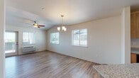Located in Saint Helens, Oregon, this single-floor home offers a clean, modern interior with consistent wood-look flooring flowing throughout every room. The open living and dining area is a standout feature, showcasing vaulted ceilings, a ceiling fan, an elegant chandelier, and multiple windows that fill the space with natural light and offer pleasant outdoor views. A glass door leads out from the living area, further enhancing the connection to the outdoors.

The kitchen is equipped with warm-toned wood cabinetry, granite-style countertops, and black appliances including a Whirlpool refrigerator, electric range, and over-the-range microwave. A convenient breakfast bar provides additional seating and counter space.

Multiple bedrooms offer bright, neutral interiors with the same durable flooring, and at least one bedroom features a window with a tree-lined outdoor view. A central hallway connects the rooms efficiently, with additional storage spaces visible throughout.

The bathroom features a wood vanity with granite-style countertops, a tub/shower combination with clean white surrounds, and light tile flooring. The home's neutral color palette and updated finishes create a fresh, move-in-ready atmosphere throughout.