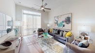 This well-appointed single-floor residence offers a thoughtfully designed open-concept layout that seamlessly connects the living, dining, and kitchen areas. The living room is a standout space, featuring warm hardwood flooring, a ceiling fan, and a large window with access to a private balcony, flooding the room with natural light and providing outdoor views. Bold abstract artwork and richly colored furnishings lend the space a vibrant, curated ambiance.

The kitchen is outfitted with dark, shaker-style cabinetry, granite countertops, a subway tile backsplash, and a full suite of stainless steel appliances including a gas range, microwave, and refrigerator. A white-topped island provides additional prep and counter space. Conveniently tucked nearby is an in-unit stacked washer and dryer.

The bedroom is a serene retreat, bathed in natural light through a large picture window. It features plush carpeting, a ceiling fan, and ample wall space accented by contemporary artwork.

The bathroom is elegantly finished with large-format marble-look tile surrounding the soaking tub and shower combo, complemented by grey cabinetry and clean white fixtures, creating a spa-like atmosphere throughout.