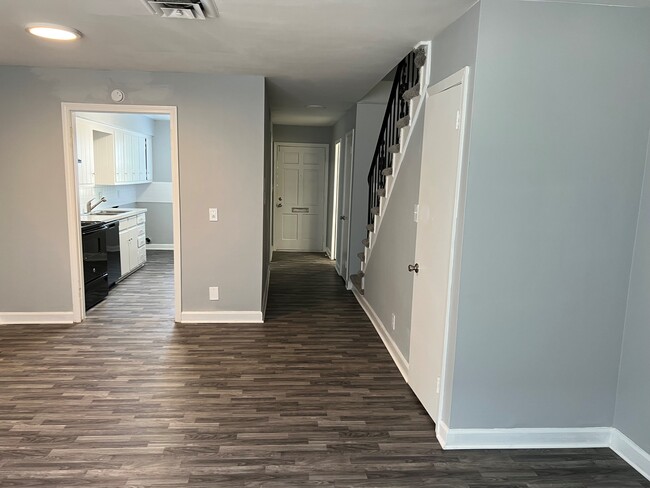 Vista de la planta baja con piso gris por toda la habitación - Townhomes at Little Creek