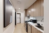 Located in the heart of West Los Angeles, this thoughtfully designed 2-bedroom, 6-bathroom unit at 1743 Butler Avenue maximizes every square foot through intelligent, modern architecture. Light wood flooring flows throughout, complemented by recessed lighting and a clean, neutral color palette that creates a bright and cohesive atmosphere.

The galley-style kitchen is efficiently outfitted with warm wood cabinetry extending to the ceiling, stainless steel appliances including a gas range, a stainless sink, and a dedicated space for a stacked washer and dryer — offering full functionality in a compact footprint.

Each bedroom is designed around space-saving murphy beds, allowing the rooms to serve dual purposes. The primary bedroom features built-in wood cabinetry for ample storage, a wall-mounted TV, and light wood flooring, while the secondary bedroom includes a sofa and wall-mounted AC unit. Both rooms are accessed via well-appointed hallways with smart home control panels installed at entry points.

The six bathrooms are sleekly finished with large-format tile, glass-enclosed walk-in showers, wood-toned vanity cabinetry, and clean white countertops. Artwork accents the hallways, adding a curated touch to the modern interior. This unit is a prime example of efficient, contemporary urban living.