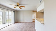 Located at 1032 Hidden Harbour Dr in Melbourne, Florida, this 2-bedroom, 1-bathroom residence offers a practical and comfortable single-floor layout. The open-concept living room and kitchen area serves as the heart of the home, with the kitchen featuring stainless steel appliances — including a refrigerator, range, and dishwasher — white cabinetry, light stone countertops, a tile backsplash, and wood-look flooring illuminated by track lighting. The living area is carpeted and connects seamlessly to the kitchen via a pass-through opening, with a front entry door providing direct access.

The spacious primary bedroom features plush carpeting, a ceiling fan, a textured ceiling, and sliding glass doors that open to a private balcony with pleasant outdoor views. The second bedroom is also carpeted and benefits from a large window that fills the room with natural light and views of the surrounding greenery. A dedicated hallway leads to the full bathroom, which includes a single-sink vanity with white cabinetry, a combined tub and shower, and dark wood-look flooring. Additional conveniences include a hallway closet, in-unit laundry, and a dedicated storage closet, rounding out this functional and comfortable Melbourne residence.