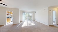 This single-floor residence offers a clean, well-lit layout designed for comfortable everyday living. The living room serves as the heart of the home, featuring soft wall-to-wall carpeting, a ceiling fan, and a large sliding glass door that opens to a private balcony overlooking lush, tree-lined surroundings. Natural light floods the space throughout the day, creating a warm and inviting atmosphere.

Adjacent to the living area, the galley-style kitchen is efficiently organized with warm wood cabinetry, dark countertops, and white appliances including a gas range and refrigerator. A window above the countertop brings in additional natural light, making the space feel open despite its compact footprint.

The bedrooms are generously proportioned, each carpeted and featuring windows with blinds that frame views of the surrounding greenery. One bedroom includes an expansive wall of bifold closet doors, offering exceptional storage capacity. The rooms are finished with crisp white walls that enhance the sense of light and space.

The bathroom is appointed with tile flooring, warm-toned wall tiles, a white vanity with under-cabinet storage, a mirrored medicine cabinet, and vanity lighting — providing a functional and tidy space. Throughout the residence, neutral tones and consistent finishes contribute to a cohesive, move-in-ready aesthetic.