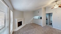 This well-appointed 2-bedroom, 1-bathroom home in Lafayette, Louisiana offers a thoughtfully designed single-floor layout that maximizes comfort and functionality. The living room serves as the heart of the home, highlighted by a charming white-mantled corner fireplace and plush carpeting underfoot. Natural light filters in through slatted blinds on multiple windows, creating a warm and inviting atmosphere. Crown molding and a textured ceiling add classic architectural character throughout.

The kitchen connects seamlessly to the living area via an open pass-through counter topped with granite-style laminate, offering a modern and practical design. It is equipped with stainless steel appliances, including a refrigerator, gas range, and microwave, complemented by light cabinetry and a tile backsplash.

The primary bedroom is generously sized, featuring elegant French doors that invite natural light, along with a ceiling fan and access to a walk-in closet. The second bedroom is carpeted and bright, also fitted with a ceiling fan for added comfort. The bathroom includes a granite-topped vanity with gray cabinetry, a large mirror, and a tub-shower combination. A connecting hallway ties all rooms together efficiently, completing this comfortable and functional home.