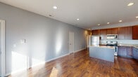 Located at 2949 N Harlem Ave in Chicago's vibrant Northwest Side, this single-floor residence offers a thoughtfully designed layout with contemporary finishes throughout. Rich hardwood flooring extends across the open living area, which is bathed in natural light through large windows and sliding glass doors that lead to a private balcony with neighborhood views. Recessed lighting adds a clean, modern touch to the bright, neutral-toned interiors.

The kitchen is a standout feature, showcasing rich dark wood cabinetry that reaches the ceiling for ample storage, granite countertops, a central island for additional prep space, and a full suite of stainless steel appliances including a gas range, microwave, refrigerator, and dishwasher.

The bedrooms are generously sized, each with hardwood floors and windows that invite natural light and views of the surrounding neighborhood. The primary bathroom features a dual-sink granite vanity, tile flooring, and a separate glass-enclosed shower, while the secondary bathroom offers a granite-topped vanity and a tiled tub-shower combination. The cool gray wall palette throughout creates a calm, cohesive ambiance, making this a well-appointed Chicago residence.