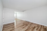 Located at 524 N Juanita Ave in Redondo Beach, CA, this two-story home offers a clean, modern aesthetic throughout. Light wood-tone flooring flows consistently across both levels, complementing the crisp white walls and creating a bright, airy atmosphere. The main level features an open living area with large windows fitted with plantation-style blinds, allowing ample natural light. A staircase connects the two floors, and baseboard heating is present in the living spaces. The galley-style kitchen is thoughtfully updated with white upper cabinets, warm taupe lower cabinets, quartz countertops, a stainless steel undermount sink, and a full suite of stainless steel appliances including a range, microwave, and refrigerator. A half bathroom on the main level features a floating wood vanity with a quartz countertop. Upstairs, the primary bedroom includes rich wood-tone flooring, a ceiling fan, and a sliding glass door opening to an outdoor balcony. Bedrooms are generously sized and include mirrored sliding closet doors. The full bathroom on the upper level is finished with quartz counters, a wood vanity, a combination tub and shower, and a wall-mounted medicine cabinet. Additional rooms provide flexible space with natural light from well-positioned windows.