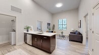 Located at 340 E Fulton St in Columbus, Ohio, this 2-bedroom, 2-bathroom residence offers a well-designed single-floor layout with impressively tall ceilings throughout, creating a bright and airy atmosphere. The open-concept kitchen and living area serves as the heart of the home, where rich dark-cabinetry contrasts elegantly with white quartz countertops. A central peninsula with seating doubles as a breakfast bar, ideal for casual dining. Stainless steel appliances, including a range, microwave, refrigerator, and dishwasher, complete the modern kitchen. Light wood-tone flooring runs seamlessly throughout, adding warmth and continuity. The living room benefits from a large window that draws in natural light and frames views of the surrounding neighborhood. Both bedrooms are comfortably sized, featuring the same soaring ceilings and light flooring, with the primary bedroom offering direct access to its own bathroom. Each bathroom is appointed with dark vanity cabinetry, white countertops, tiled tub-shower combinations, and wood-look tile flooring. Three closets provide ample storage, and a dedicated laundry area adds everyday convenience. The overall aesthetic is clean, contemporary, and well-finished throughout.