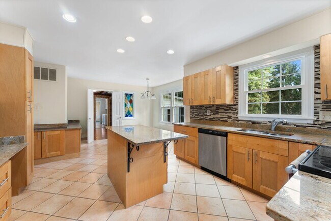 La cocina cuenta con una isla y gabinetes de arce de 42 pulgadas de alto. - 9 Snug Hill Ct
