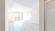 Located in the vibrant East Hollywood neighborhood of Los Angeles, this modern single-floor unit at 1111 N Kenmore Ave offers a clean, contemporary design with an open and airy feel throughout. Light-toned hardwood flooring runs seamlessly across the living spaces, complementing the crisp white walls and recessed lighting that brighten each room.

The living area is generously proportioned, featuring large black-framed sliding glass doors that open to a private balcony, inviting abundant natural light and offering open views of the surrounding Los Angeles cityscape. Additional rooms also feature sliding glass doors with balcony access, further enhancing the connection between interior and exterior spaces.

The kitchen is thoughtfully designed with two-tone cabinetry — white upper cabinets paired with bold blue-gray lower cabinets — set against a textured blue tile backsplash. Stainless steel appliances, including a gas range and microwave, add a sleek, functional touch, while louvered pantry doors provide additional storage.

The unit includes two bathrooms: a full bath featuring a soaking tub with a decorative chevron-tiled surround, a navy vanity with a white countertop, and large-format tile flooring; and a second bathroom with a similarly styled navy vanity and tile floors, maintaining a consistent, modern aesthetic throughout.