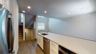 This well-designed three-story home showcases a clean, modern aesthetic throughout its multiple levels. The entry-level garage features a spacious concrete floor, automatic opener, and an interior access door, providing convenient and secure parking.

The main living level centers around a contemporary kitchen equipped with stainless steel appliances, including a smooth-top electric range, built-in microwave, and dishwasher. White shaker-style cabinetry pairs with light quartz countertops and a neutral tile backsplash, while recessed lighting illuminates the space. A staircase connects the floors, and strategically placed windows allow natural light to flow through the open layout.

Bathrooms feature neutral tile surrounds with tub-shower combinations, white vanities with undermount sinks, chrome fixtures, and large mirrors that enhance the sense of space.

The bedrooms offer plush carpeting and ample natural light from windows fitted with blinds. One standout room boasts impressively soaring ceilings, lending an airy, open feel. Additional carpeted rooms provide flexibility for various uses. Throughout the home, a cohesive neutral color palette and consistent finishes create a polished, move-in-ready atmosphere.