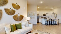 Located at 7950 Park Blvd N in Pinellas Park, Florida, this single-floor residence offers a thoughtfully designed open-concept layout that seamlessly connects the living, dining, and kitchen areas. The kitchen is a standout feature, boasting granite countertops, white shaker cabinetry, stainless steel appliances including a french door refrigerator, built-in microwave, and dishwasher, as well as a large island with bar seating illuminated by sleek chrome pendant lights. Light wood-look flooring flows consistently throughout the unit, enhancing the sense of continuity and space. The living area is generously proportioned, bathed in natural light from large windows and sliding glass doors that provide outdoor access. The bedrooms are well-sized and serene, with one featuring a window with outdoor views and ample natural light, while the primary suite includes a walk-in closet with built-in shelving and a private en-suite bathroom. The primary bathroom is equipped with a dual-sink granite vanity, white cabinetry, and bright windows for natural ventilation. Throughout the residence, neutral tones, recessed lighting, and clean architectural lines create a calm, contemporary ambiance well-suited to the Florida lifestyle.