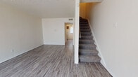 Located at 521 N Council Rd in Oklahoma City, Oklahoma, this two-story residence offers a practical and well-organized layout across both floors. The main level features an open living area with wood-look plank flooring and neutral white walls beneath a textured ceiling, creating a clean and versatile space. A carpeted staircase with a handrail leads to the upper floor, providing a clear separation between the living and sleeping areas. The kitchen is equipped with rich dark cabinetry, light-toned countertops, a double-basin sink, a dishwasher, an electric range, and a refrigerator, offering ample storage and workspace. A full bathroom on the lower level includes a tub-shower combo with a white surround, a toilet, and wood-look flooring. The upper floor hosts multiple bedrooms, each carpeted and finished with neutral tones, textured ceilings, and windows that allow natural light to filter in. A second bathroom upstairs features a dark wood vanity with a countertop sink, a large mirror, and wood-look flooring, providing a functional and tidy space. Throughout, the home maintains a consistent, straightforward aesthetic suited for comfortable everyday living.